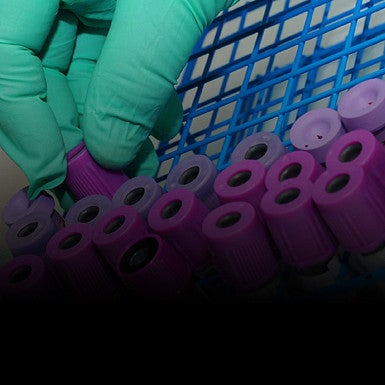 test tubes and gloved hand close up square